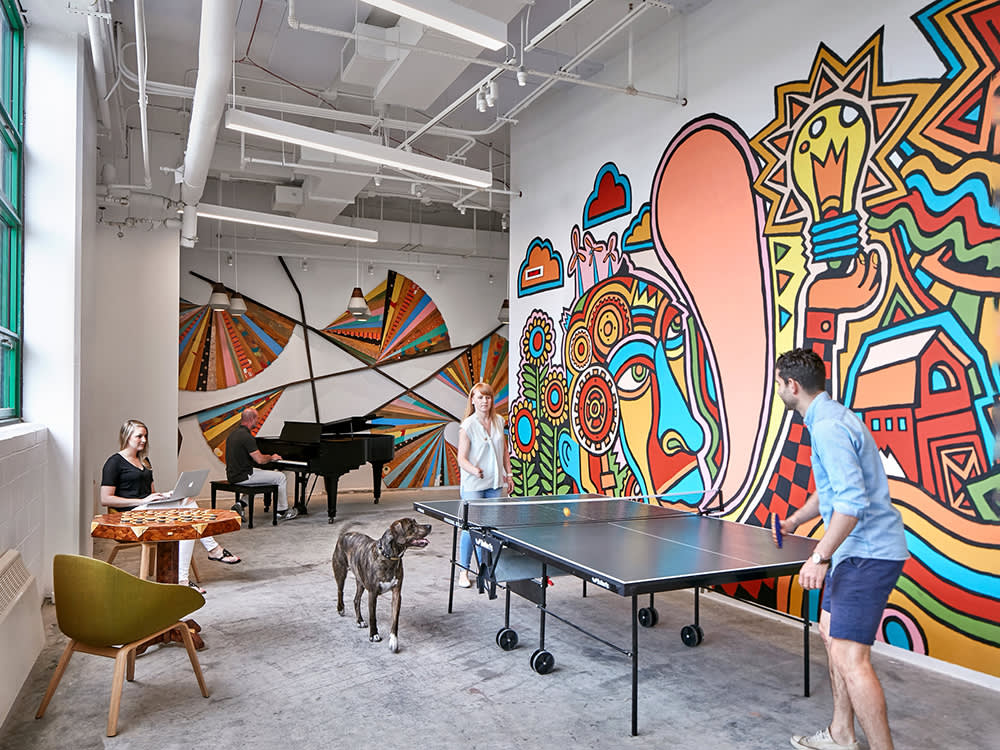 Etsy employees at a ping pong table with a dog 
