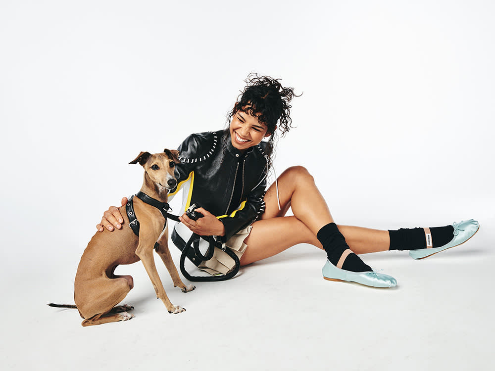 a person on the ground with a small brown dog