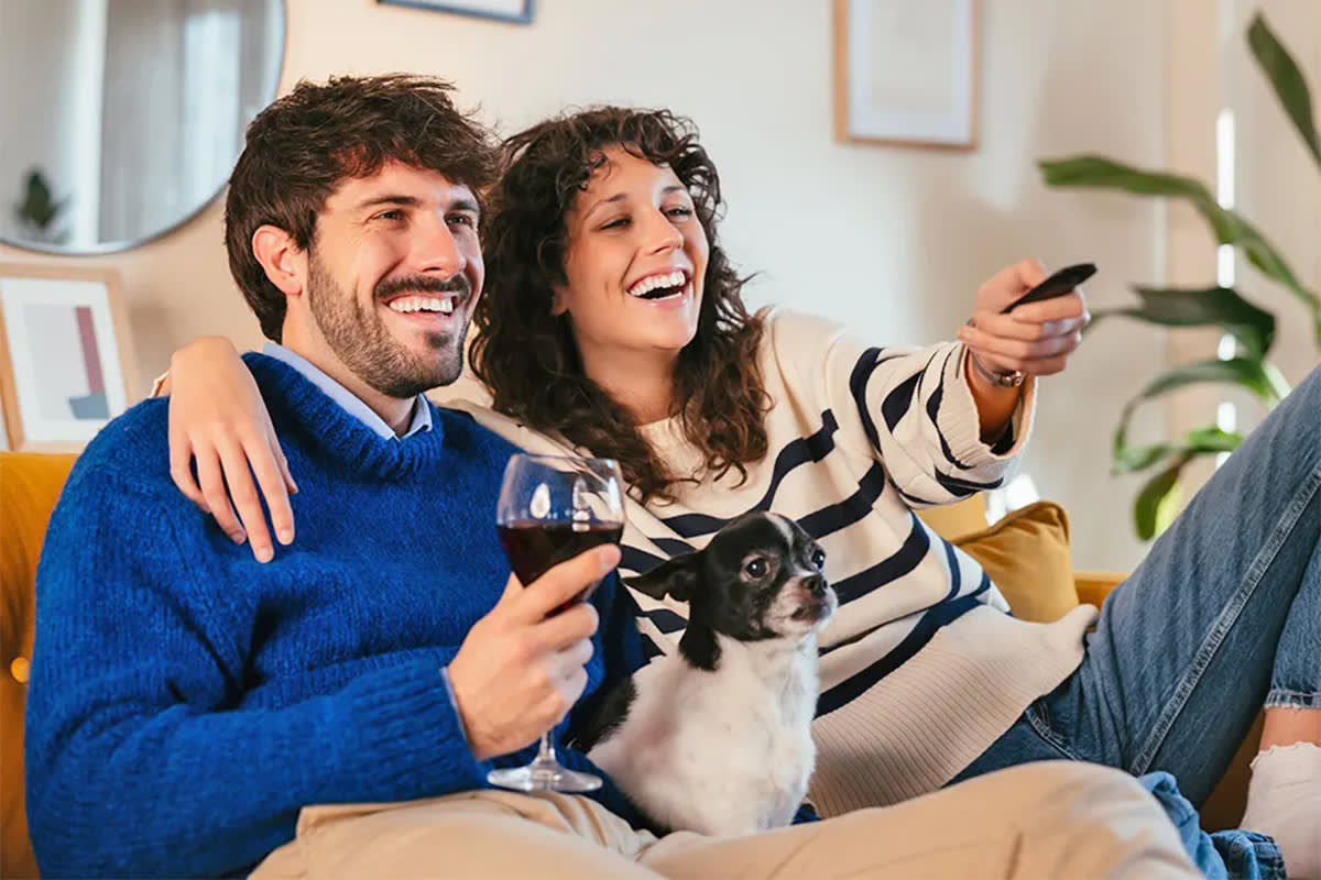 Dog watching TV with people