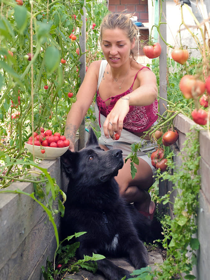 Woman in the garden with her large black dog.