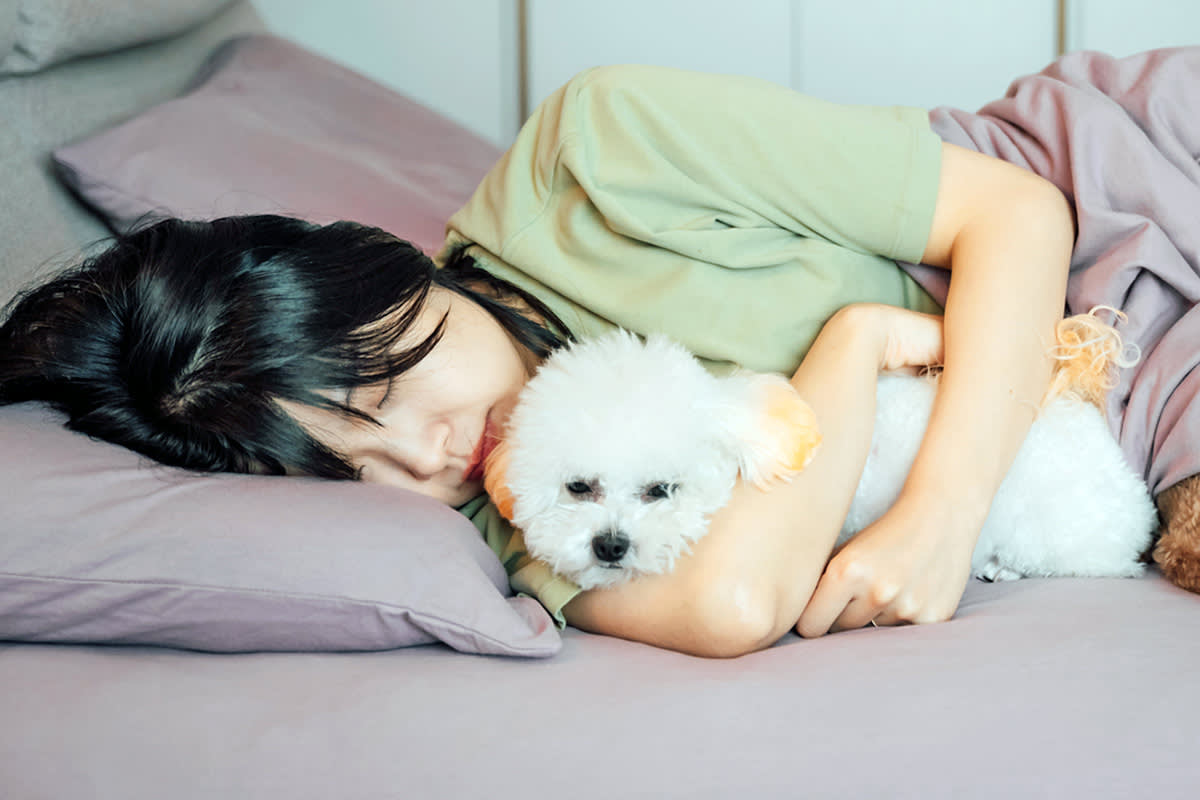 person sleeping with dog in bed