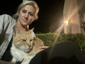 girl with blonde hair with ginger cat on her lap