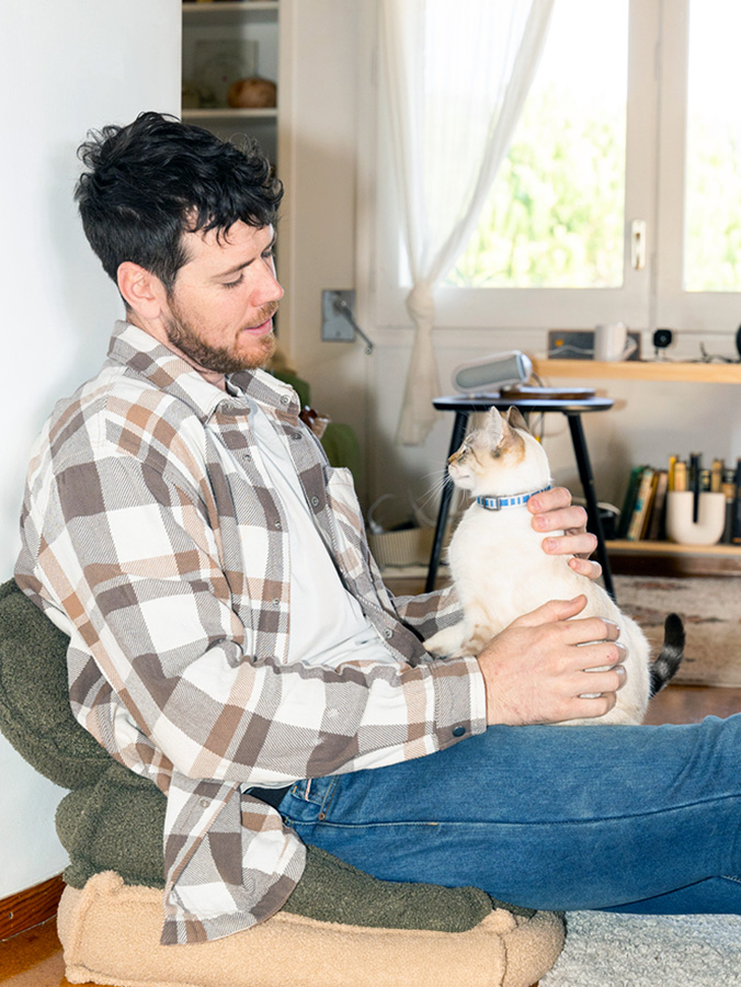 Man looking at his pet cat at home.