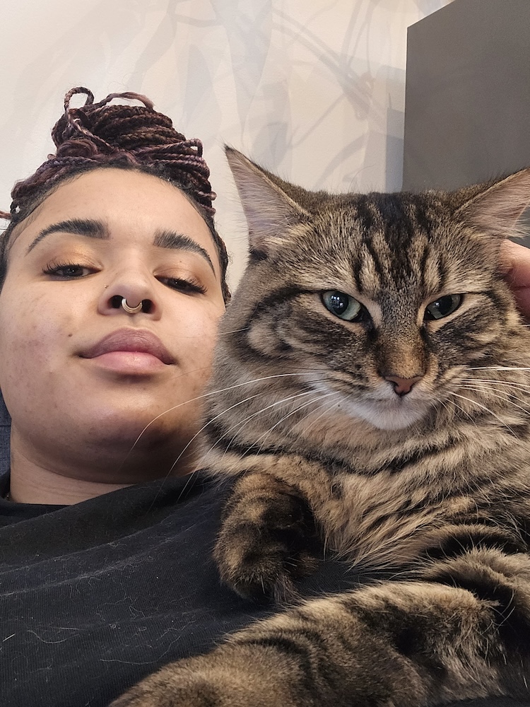 a close up of a woman with a cat on her lap