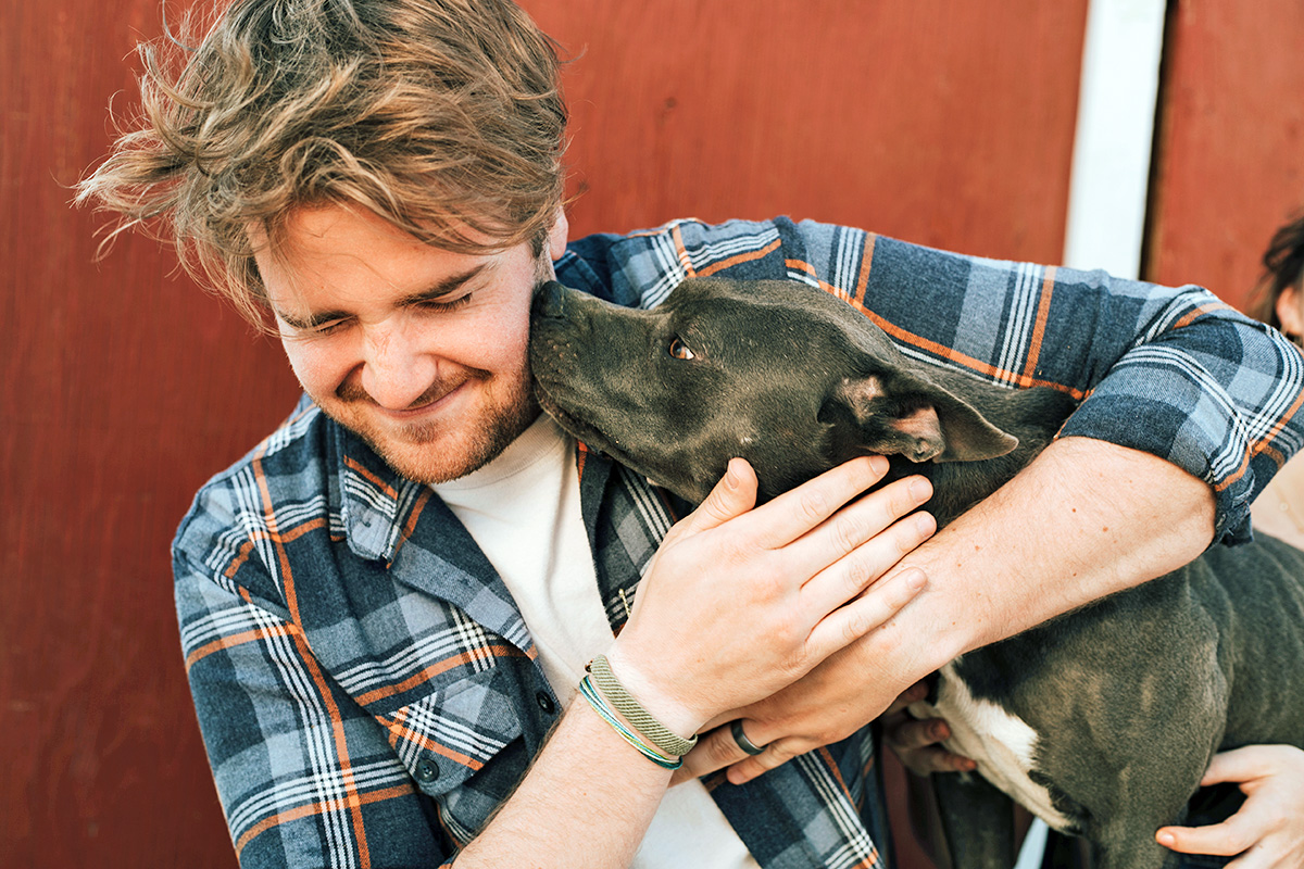 man gets kisses from his dog 