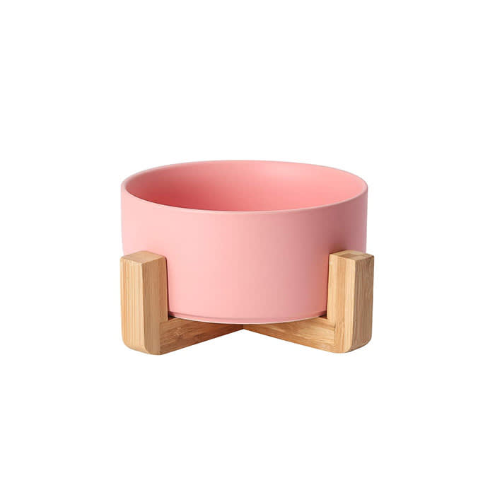 the pink ceramic bowl on a wood stand