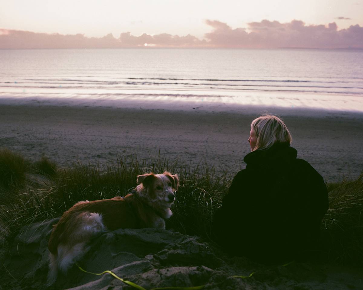 Silhouette of dog and woman by a beach in wales