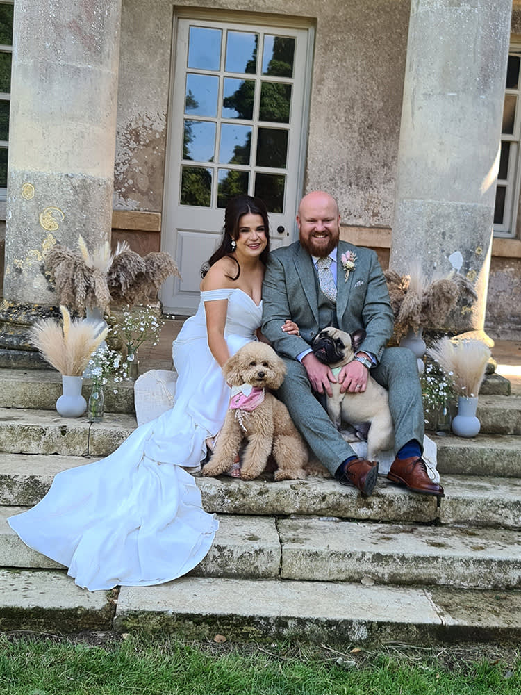 Bride and groom on their wedding day with their two dogs