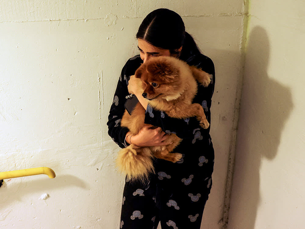 An Israeli woman hugs her dog in a bomb shelter while sirens sound as rockets from Gaza are launched towards Israel in Ashkelon, southern Israel.