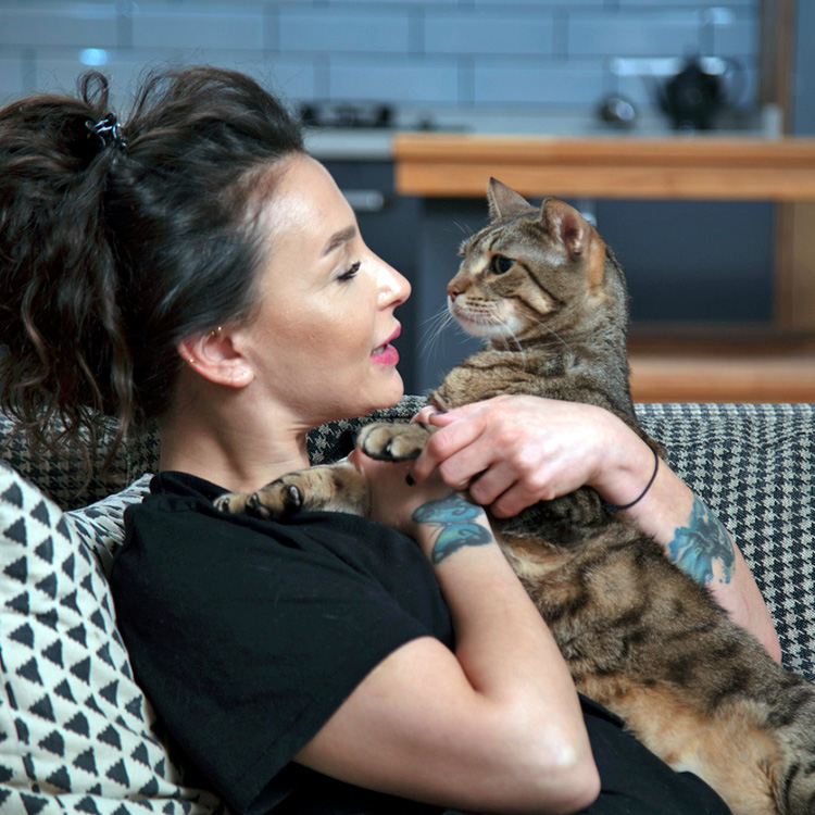 Woman talking to her cat at home.