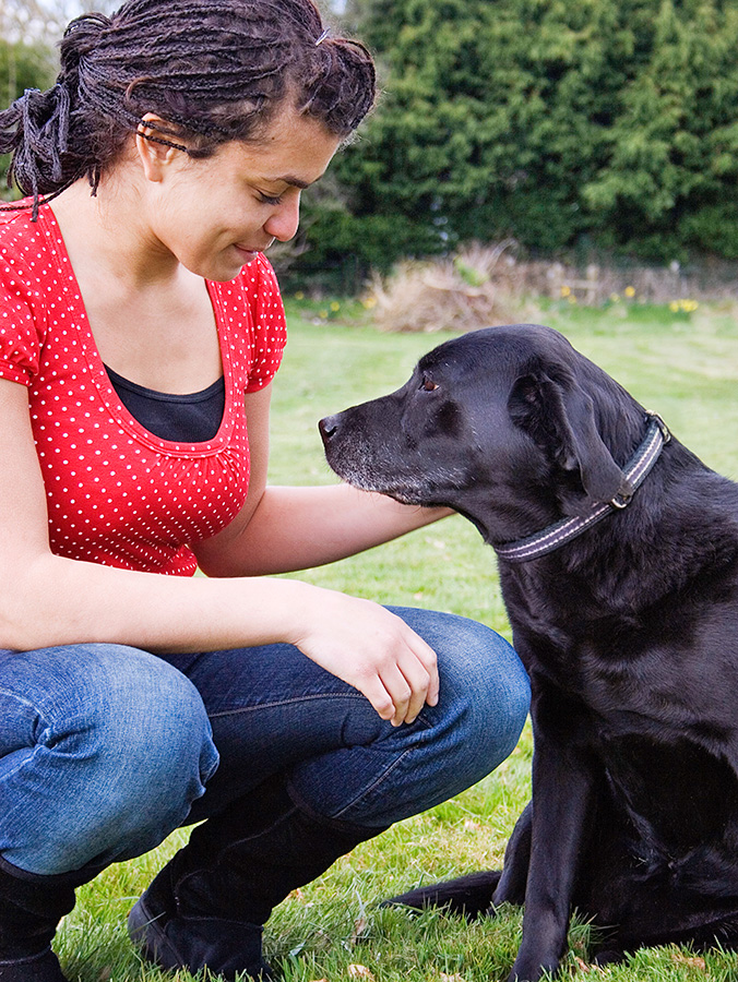 Woman petting her senior dog outside.