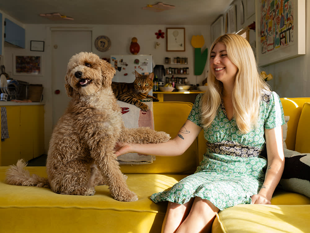 Lorien Stern with her dog on a yellow couch