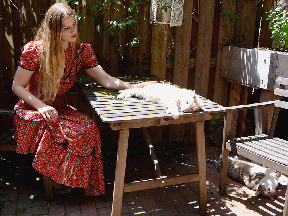 Laura Helms sits outdoors petting her cat