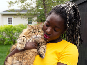 Woman hugging her hypoallergenic pet cat outside.