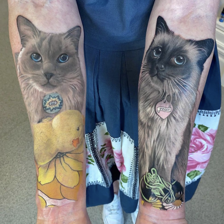 A full colour tattoo of a grey and white cat. 