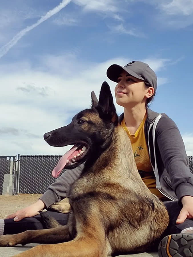 Saharai “Sada” Salazar and a large Belgian Malinois dog who is part of the Wolfmother K9 Rescue.