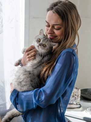 a woman hugging her cat with blonde hair