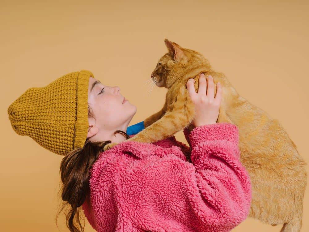 Woman playing with her orange cat.