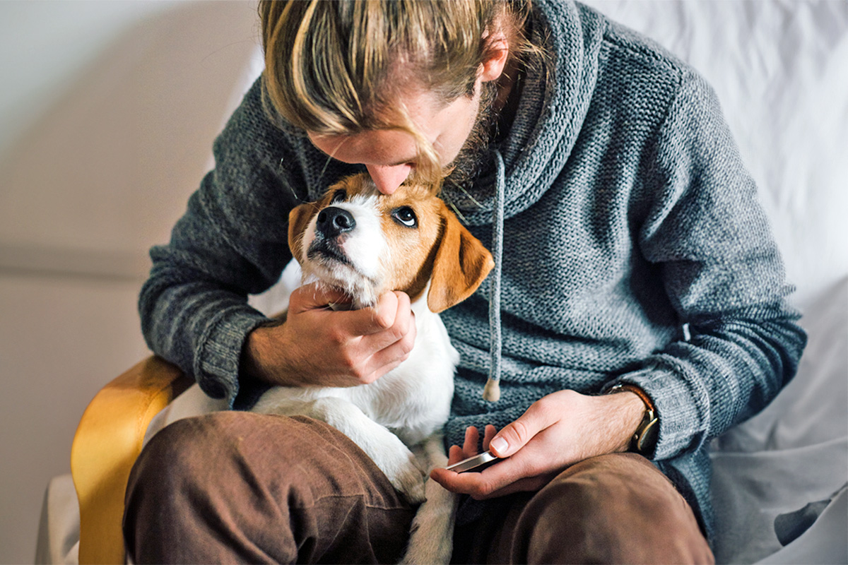 white man cuddling dog on his lap