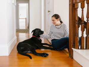 Teenager playing with a black Labrador at Home at the top of the steps