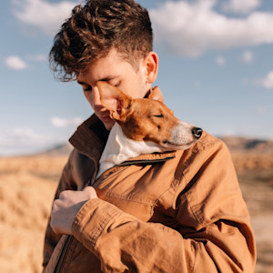 person holding a dog in the desert