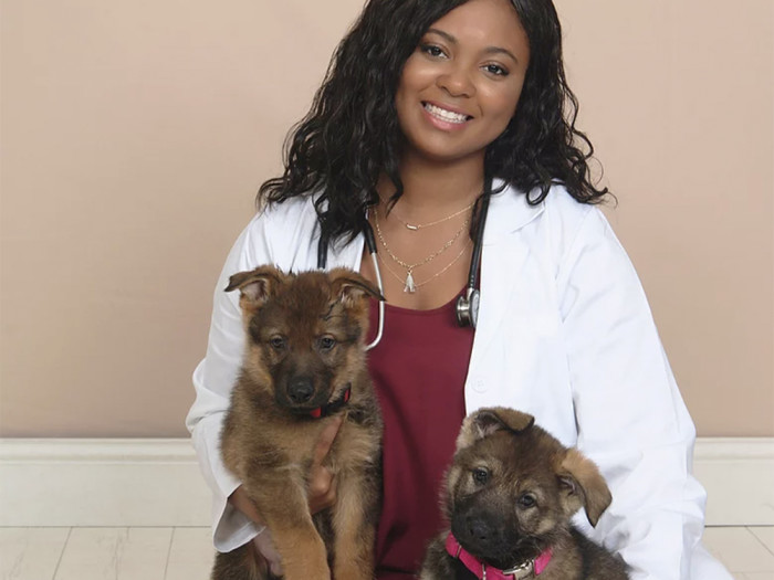 Dr. Tierra Price smiling with two puppies. 