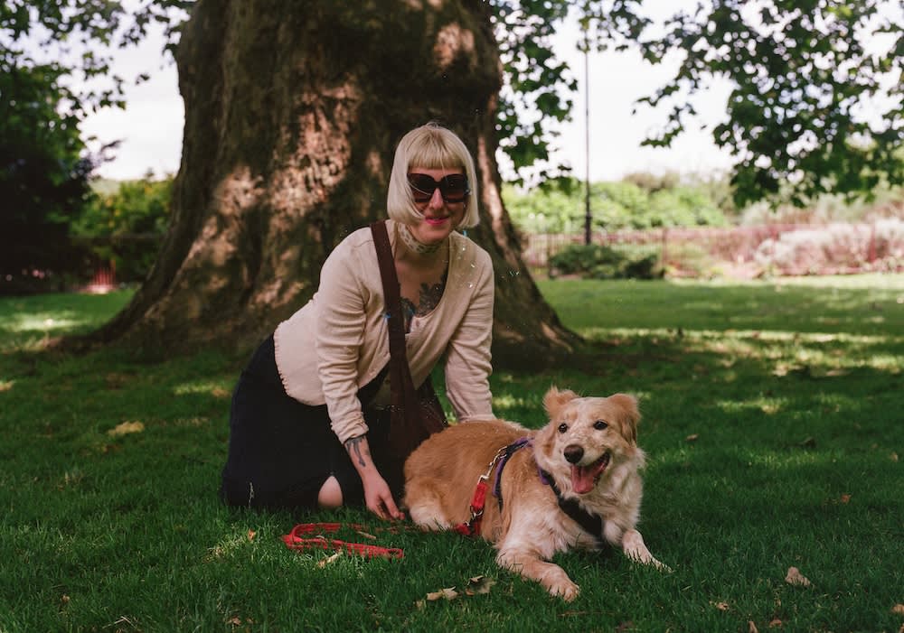a woman and her dog under a tree