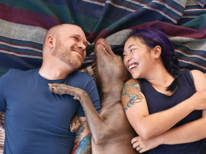 Happy pet owners cuddling with their dog 