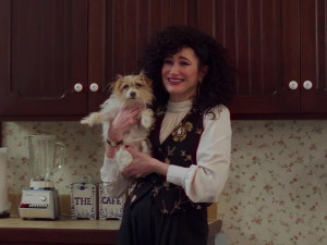 A woman holding a dog with a big smile. 