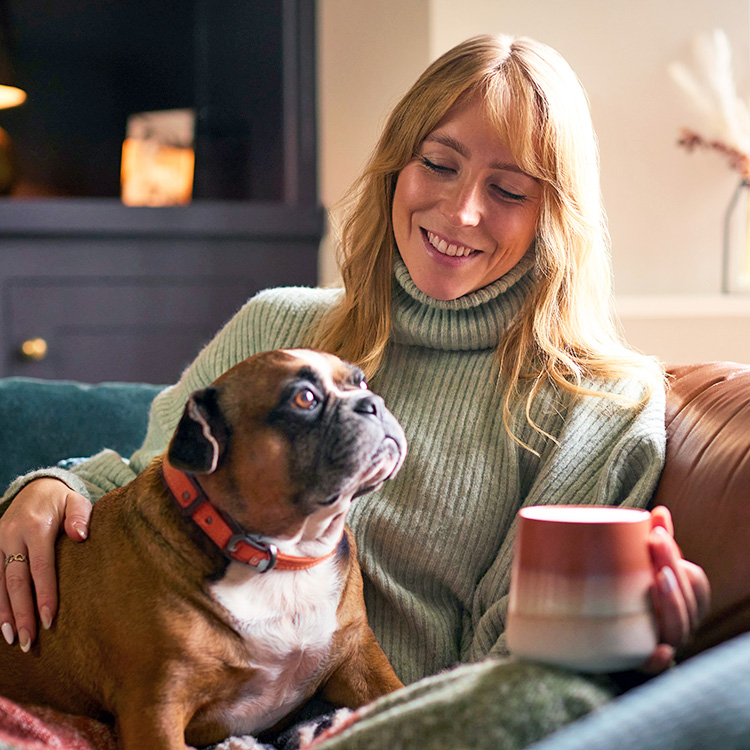Woman snuggling at home with her dog.