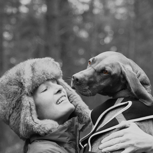 black and white image of woman lifting up dog