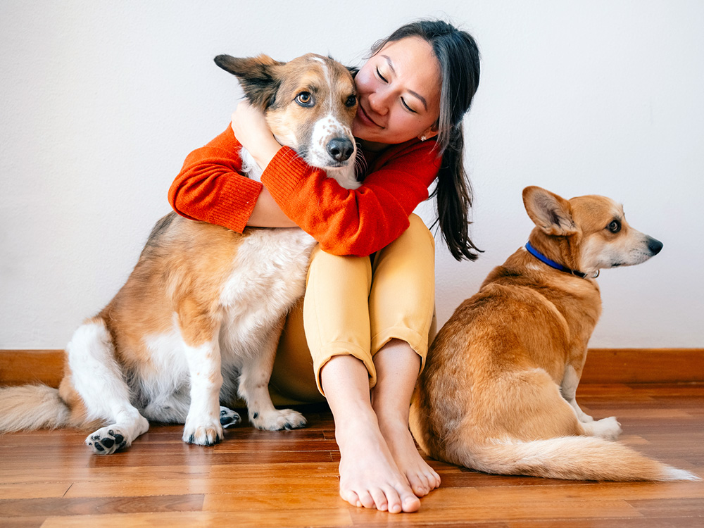Woman hugging her dog at home.