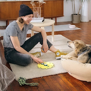 Woman teaching her dog how to use speech buttons.