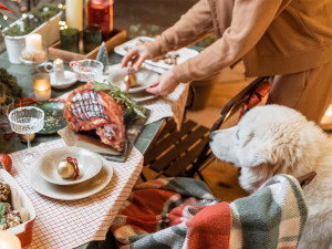 Woman serving and decorating a festive dinner table on the christmas eve outdoors on the terrace.
