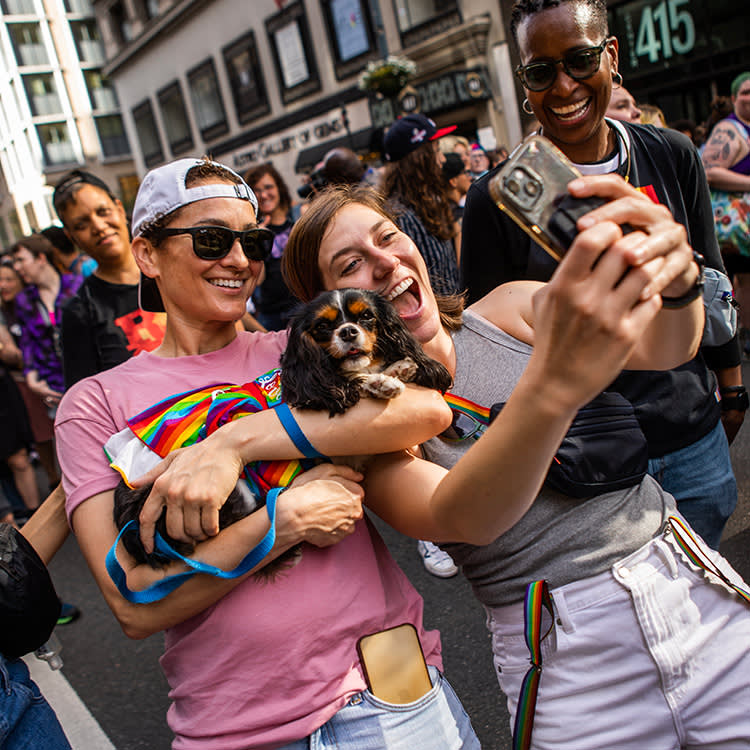 Women holding their dogs at Dyke March 2023 in NYC.