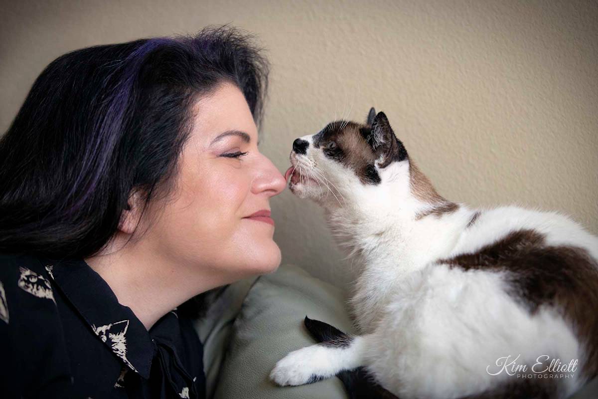 Marci Koski greets a black-and-white cat.