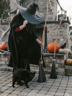 person in witches costume with a black cat