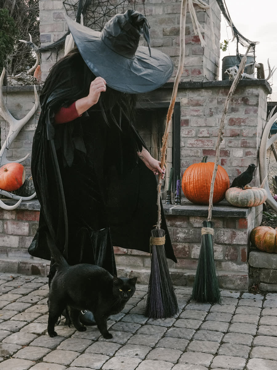 person in witches costume with a black cat