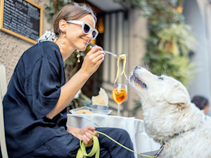 Woman and dog outside at a cafe.