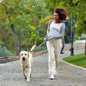 Woman walking her dog outside.