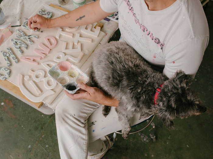 Seth Bogart paints with his dog on his lap 