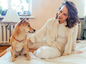 Woman looking at her dog at home.