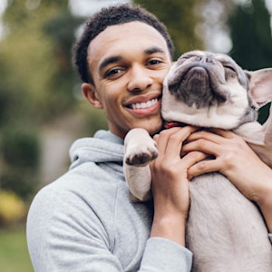 picture of trent alexander-arnold holding a french bulldog and smiling