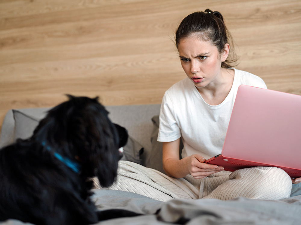 Woman looking angrily at her dog at home.