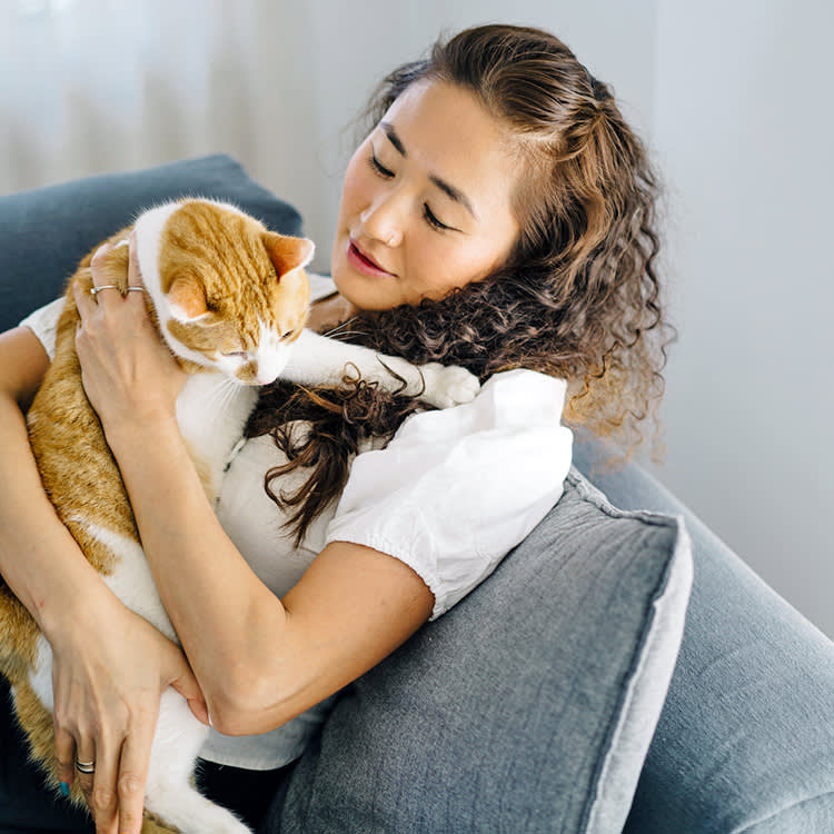 Woman holding her cat and looking concerned.
