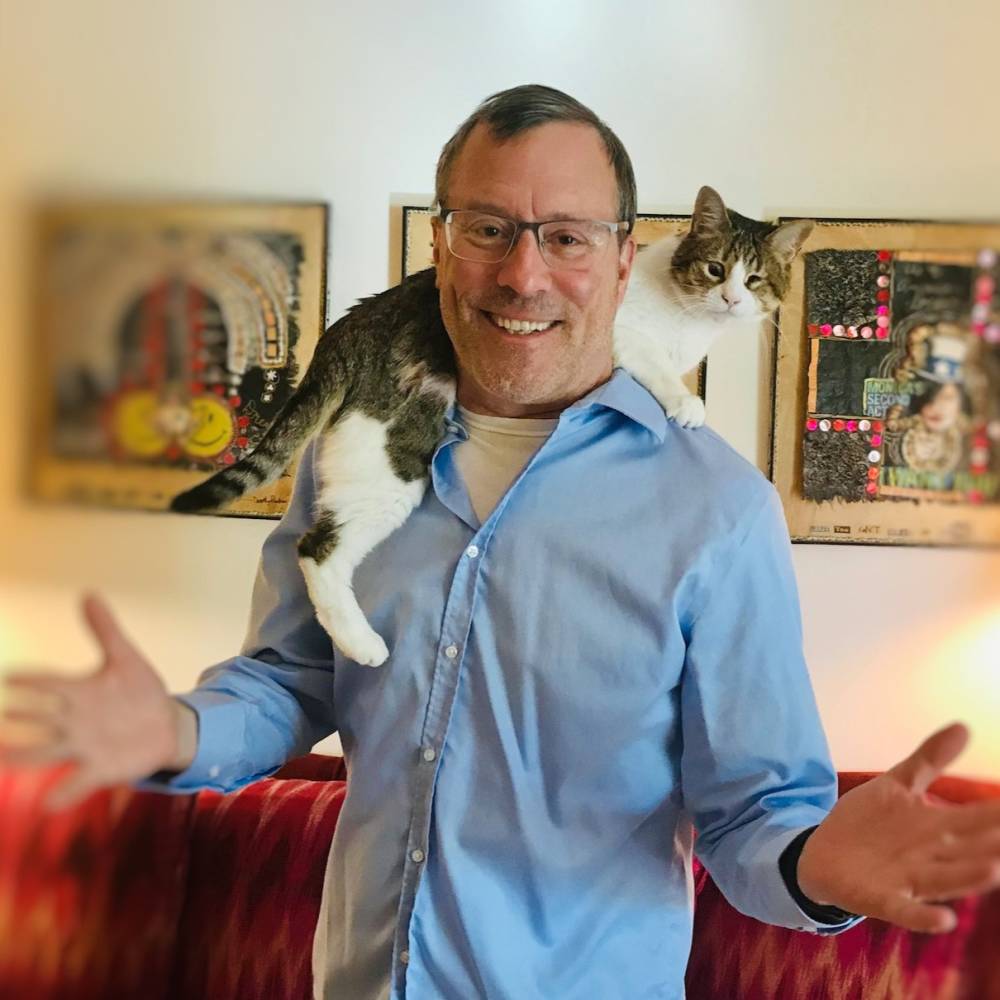 Stephen Quandt stands with a cat on his shoulders
