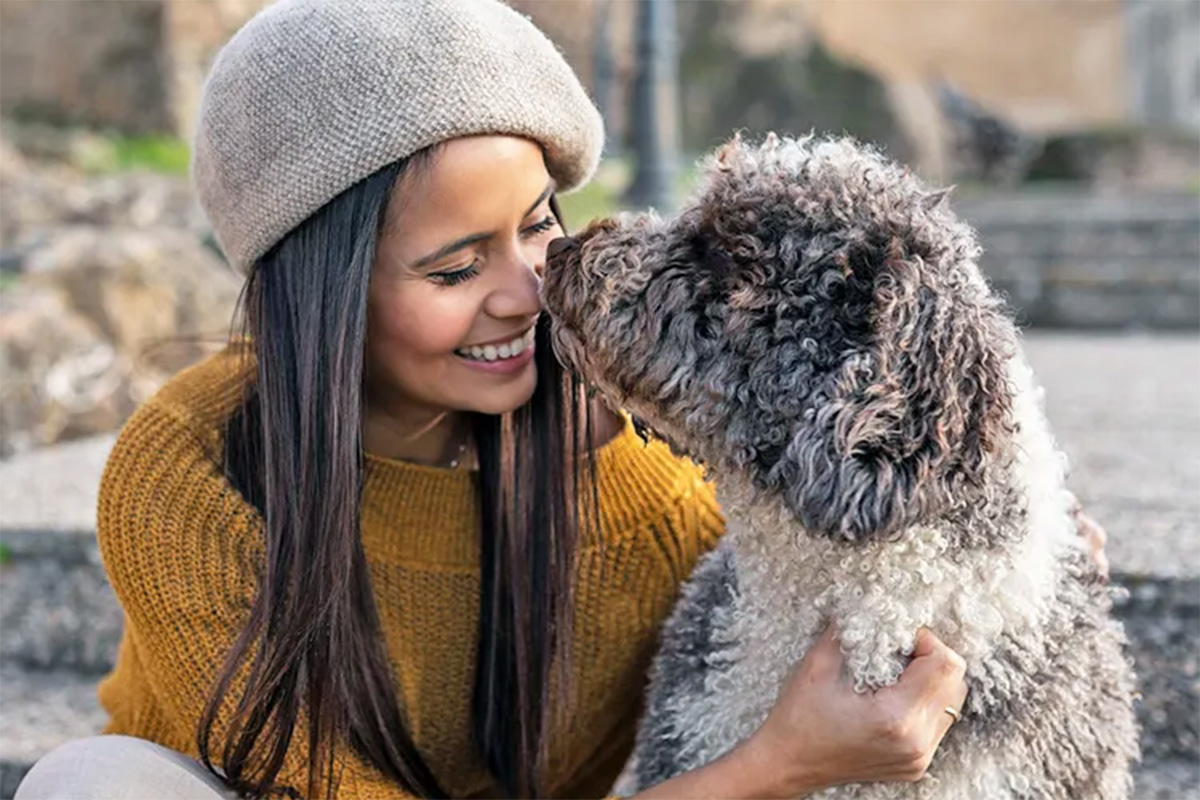 a woman snuggles with her dog 