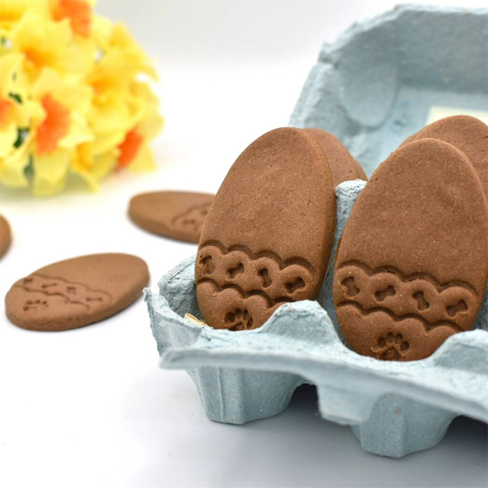Egg-shaped dog biscuits presented in an egg box