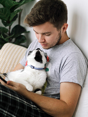 Man looking at his cat's face at home.