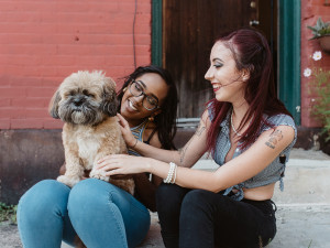 two girls bonding over a cute fluffy dog